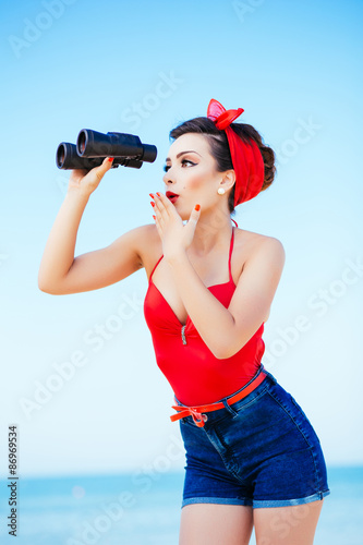 Fotografie Pin-up at sea with binoculars