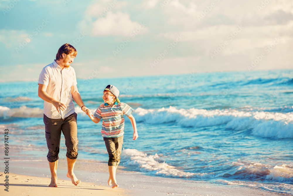 Father and son having great family time at ocean shore on summer Father and son having great family time at ocean shore on summer