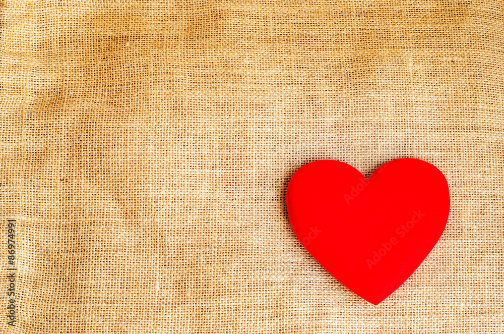Red heart on gunny sackcloth texture background with grunge retr