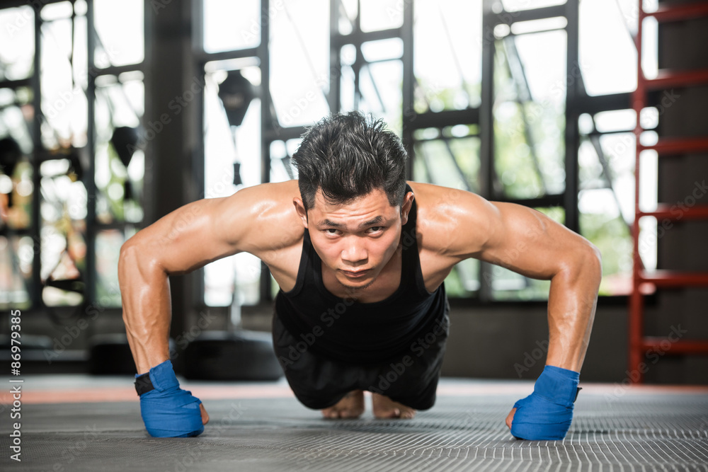 Attractive muscular man doing push-ups on gym floor Attractive muscular man doing push-ups on gym floor