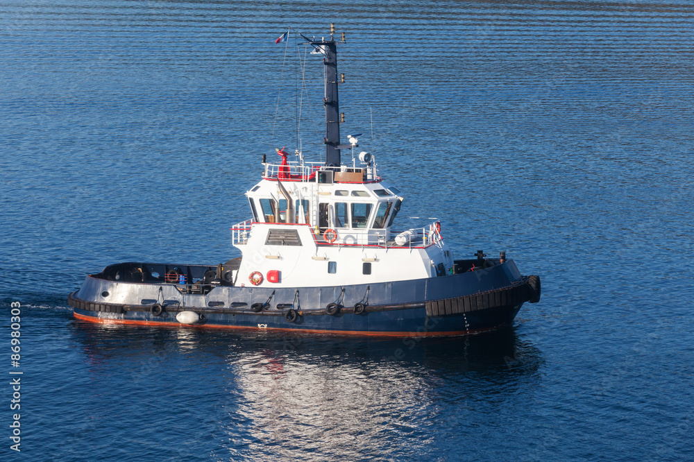Tug boat with white superstructure and dark blue hull Tug boat with white superstructure and dark blue hull