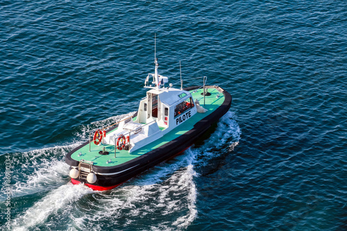 Small pilot boat with green deck and black hull
