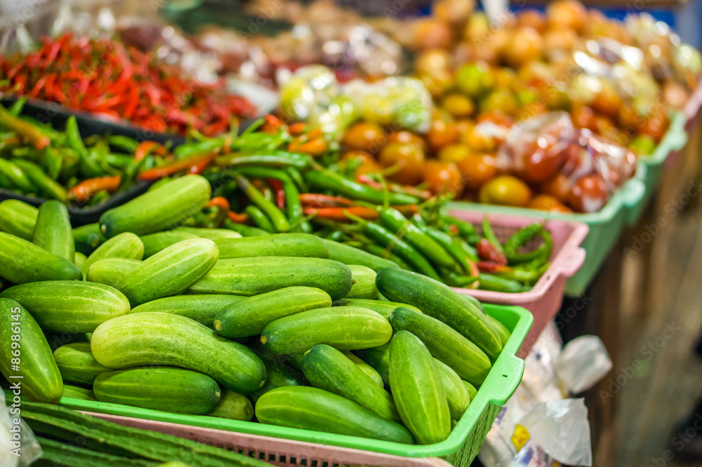 Heap of cucumbers (Cucumis sativus) in plastic basket for sale