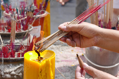 The woman is incensing bundle of joss stick