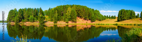Panorama of village pond and forest reflection