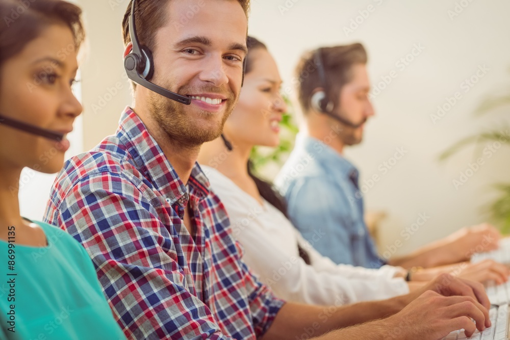 Smiling businessman working in a call centre Smiling businessman working in a call centre