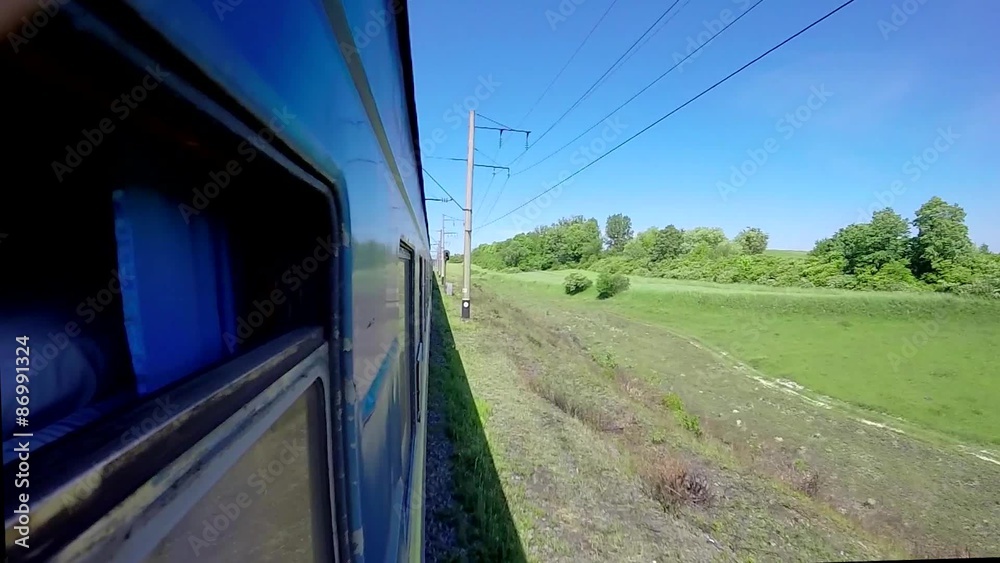 Rapid motion view of a green scenery from a high speed train window.