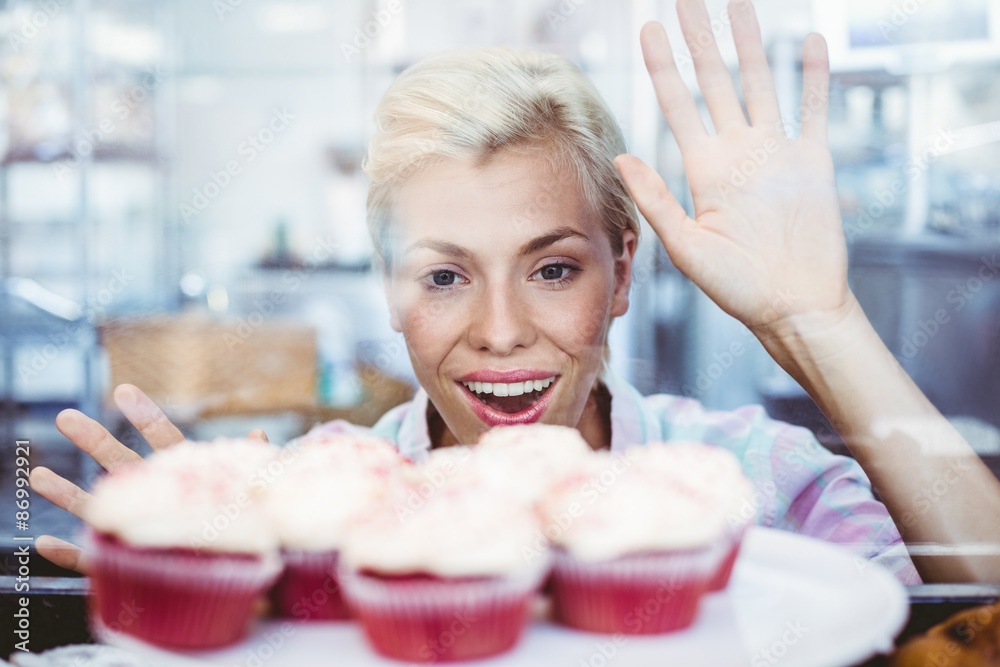 Astonished pretty woman looking at cup cakes Astonished pretty woman looking at cup cakes