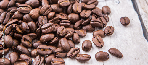 Roasted coffee beans over rustic wooden background