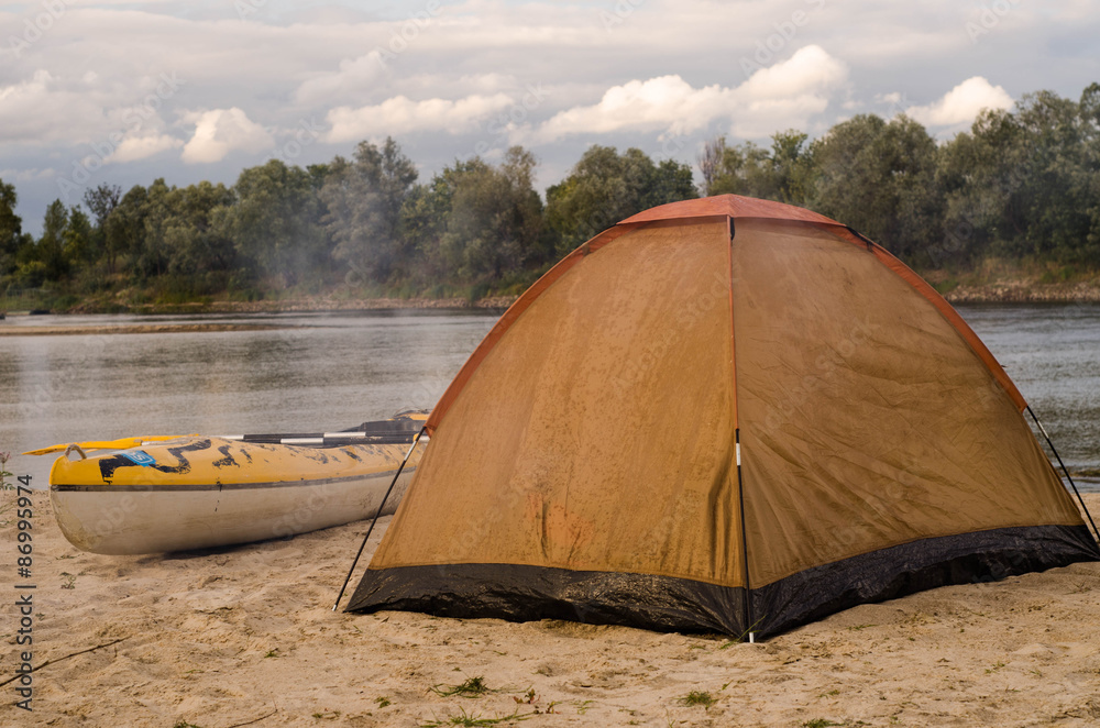 Tent on the riverside with kayak
