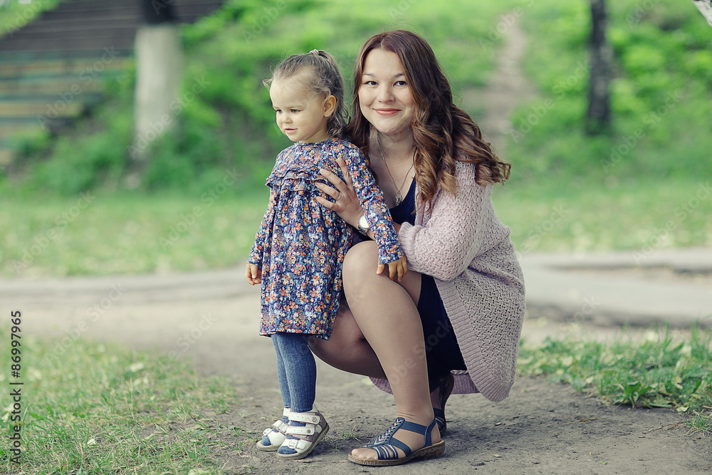 Mom and daughter in the park a young family Mom and daughter in the park a young family