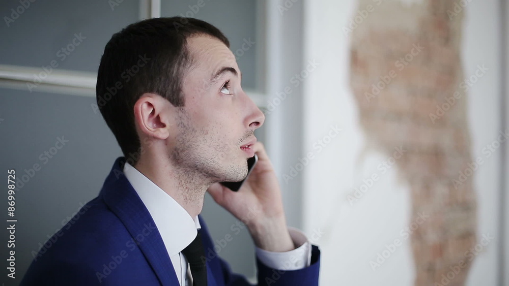 Handsome businessman talking on the phone and looking up Handsome businessman talking on the phone and looking up