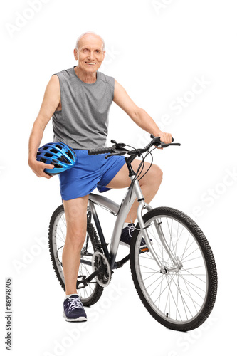 Senior biker holding a blue helmet seated on his bike