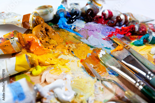 Art palette with oil paints and brushes.