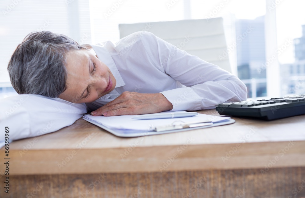 Tired businesswoman sleeping at her desk Tired businesswoman sleeping at her desk