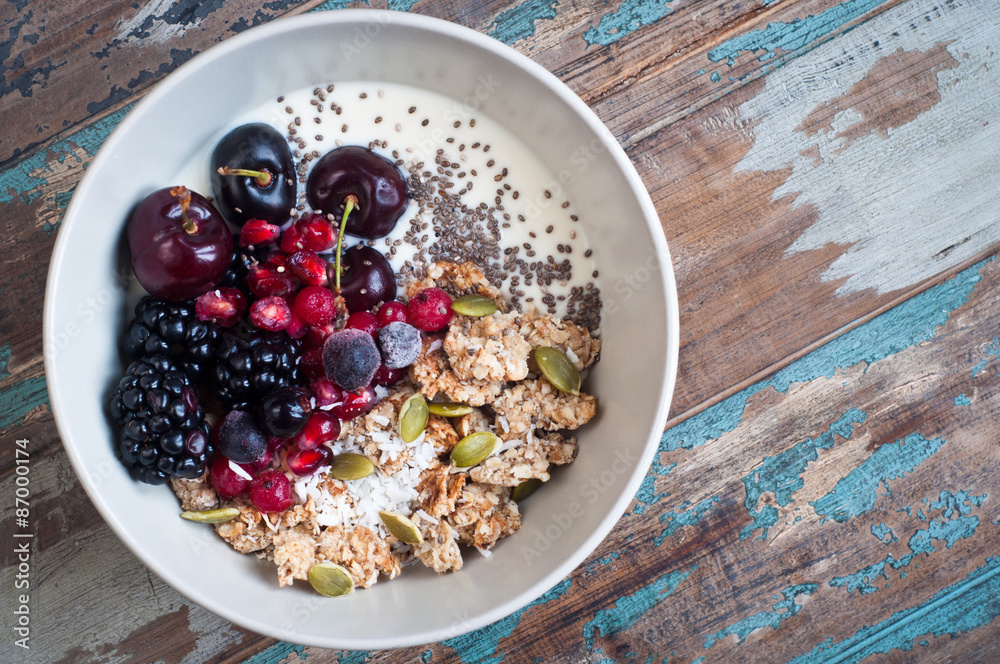 Fotografie Healthy home made oatmeal porridge muesli with kefir yogurt and topped with blackberries, cherries,pomegranate, pumpkin and chia seeds