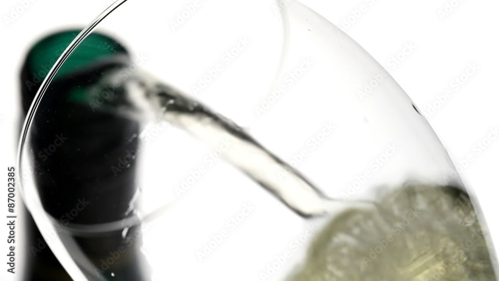 White wine poured into glass from bottle isolated on white background