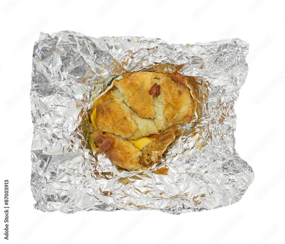 Bacon egg and cheese croissant breakfast sandwich on tinfoil