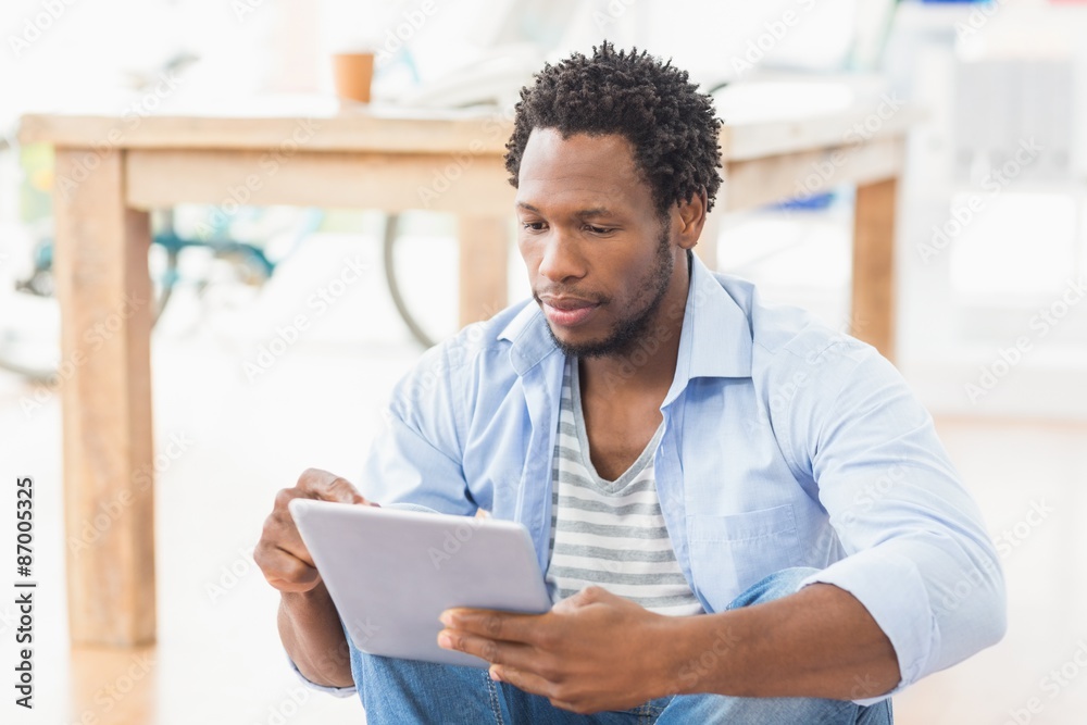 Young creative businessman scrolling on the tablet Young creative businessman scrolling on the tablet