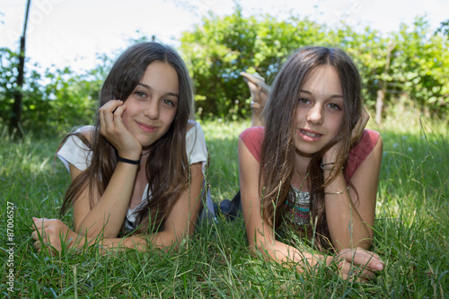 Front view of young girls laying on the grass