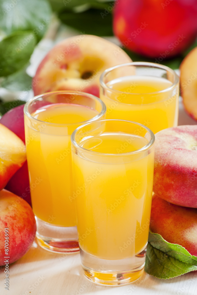 Fresh peach juice with fruits on a white wooden background, sele Fresh peach juice with fruits on a white wooden background, sele