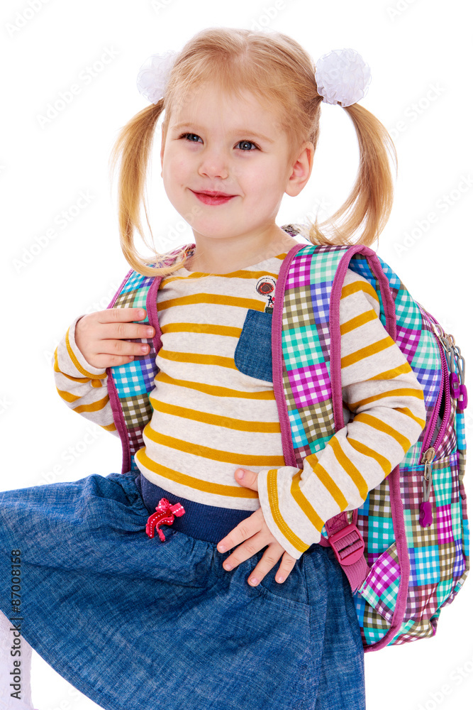 Smiling little blonde girl schoolgirl with long tails on the hea Smiling little blonde girl schoolgirl with long tails on the hea