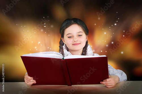 Little teen girl reads a magical fairy tutorial book smiling