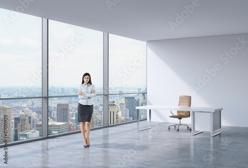 Full-length of a brunette business woman in a workplace at modern panoramic office in New York, Manhattan. A concept of financial consulting services.