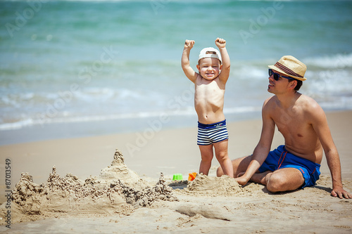 father and son build sand castle