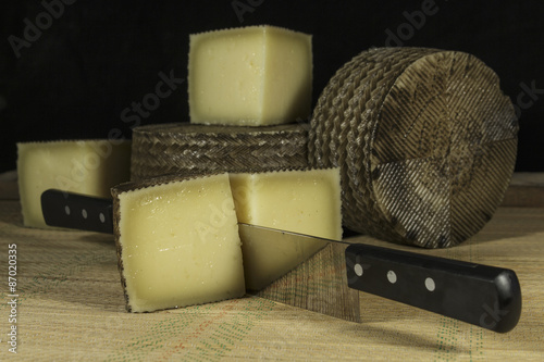 Sheep milk cheese cutted into pieces with double-handled knife