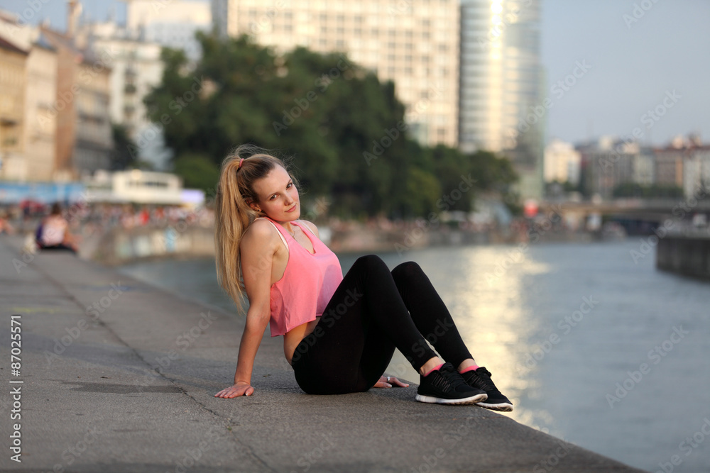 Young woman relaxes after sports in the city