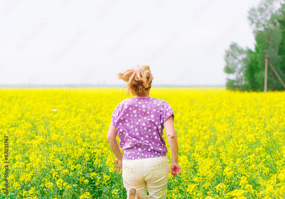 Fototapeta premium Adult woman and colza