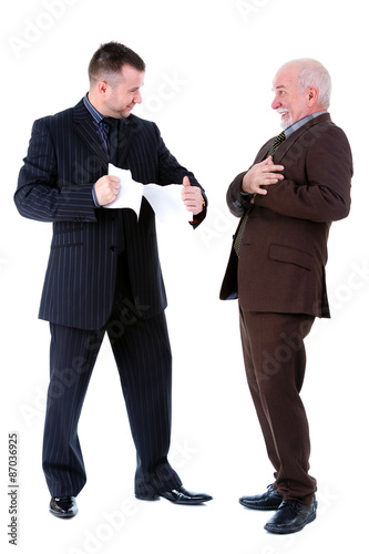 Young and old businessman in suit argue and old man getting a heart attack, holding hand on his chest, isolated on white background