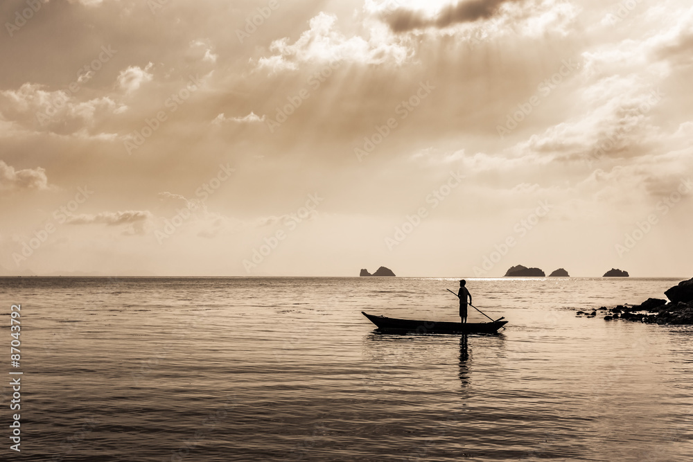 Naklejka premium silhouette of Fisherman controls the Fishing boat. sepia toned