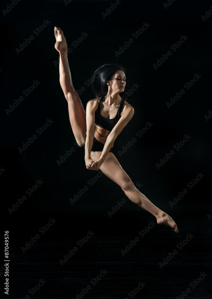 young ballet dancer dansing on black background