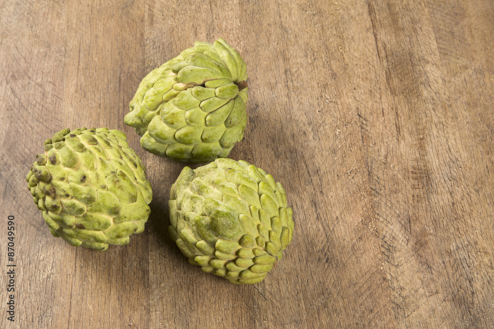 Some Sugar-Apples over a wooden table. Atemóia Some Sugar-Apples over a wooden table. Atemóia