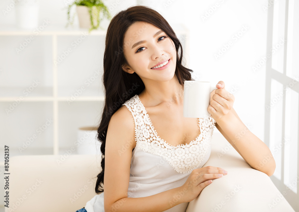 relaxed young smiling woman holding coffee cup relaxed young smiling woman holding coffee cup