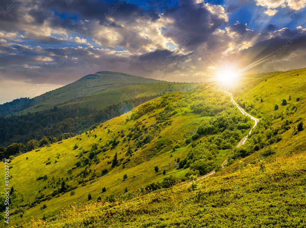 Obraz premium road through hillside in high mountains at sunset