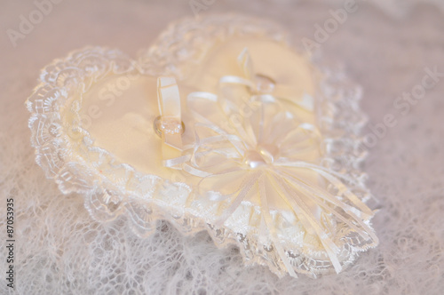 Wedding rings on a cushion with silk and lace decoration