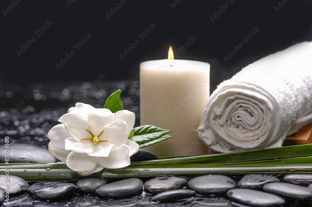 Still life with gardenia flowers with candle ,towel on therapy stones Still life with gardenia flowers with candle ,towel on therapy stones