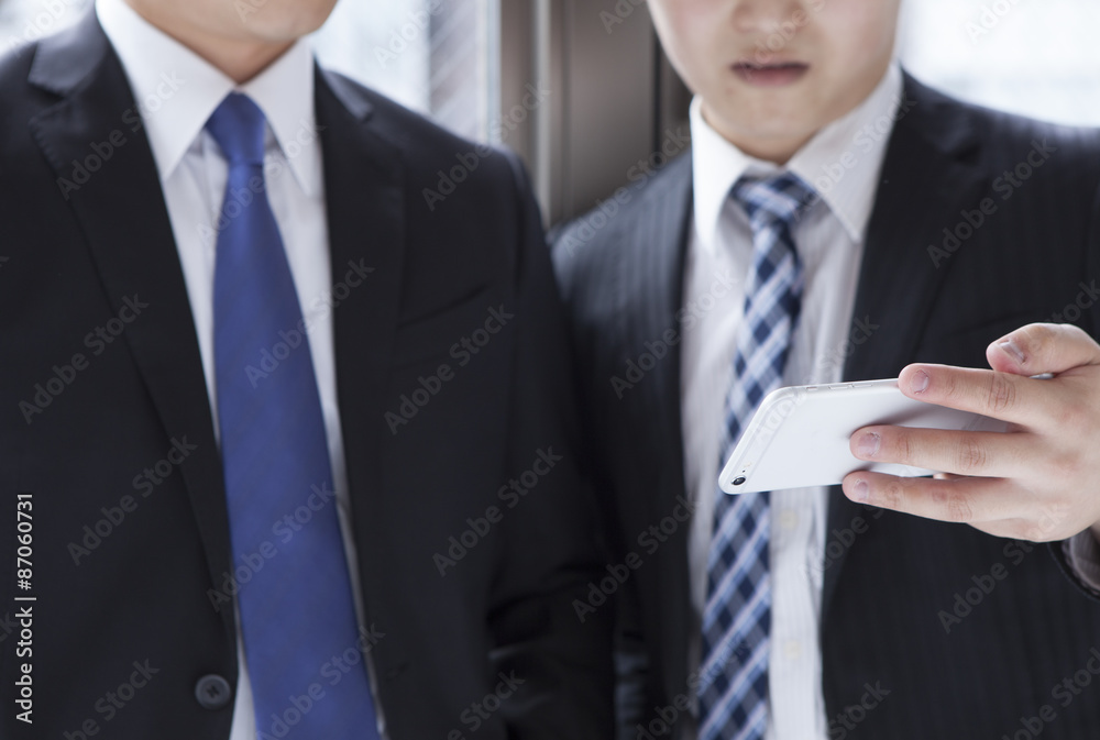 Two businessmen looking at a mobile phone Two businessmen looking at a mobile phone
