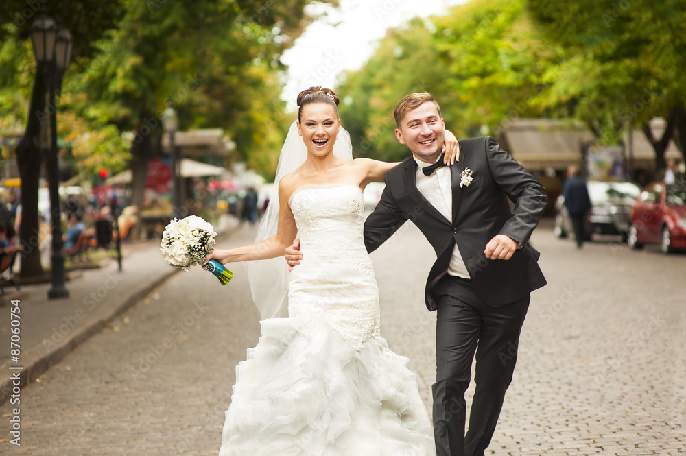 Newlyweds are walking on the street.