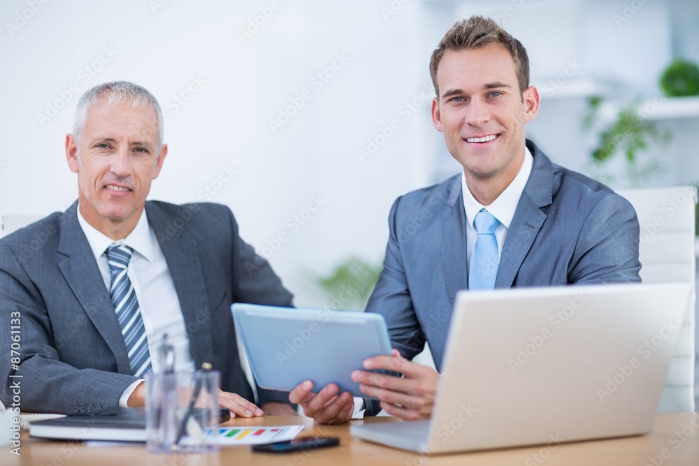 Happy businessmen working together on digital tablet Happy businessmen working together on digital tablet