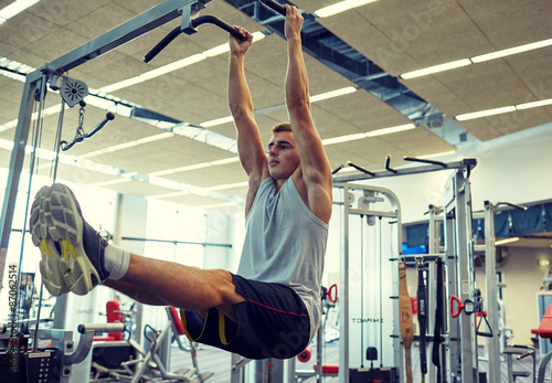 man flexing abdominal muscles on pull-up bar