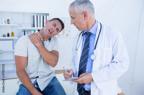 Doctor looking at patient shoulder 