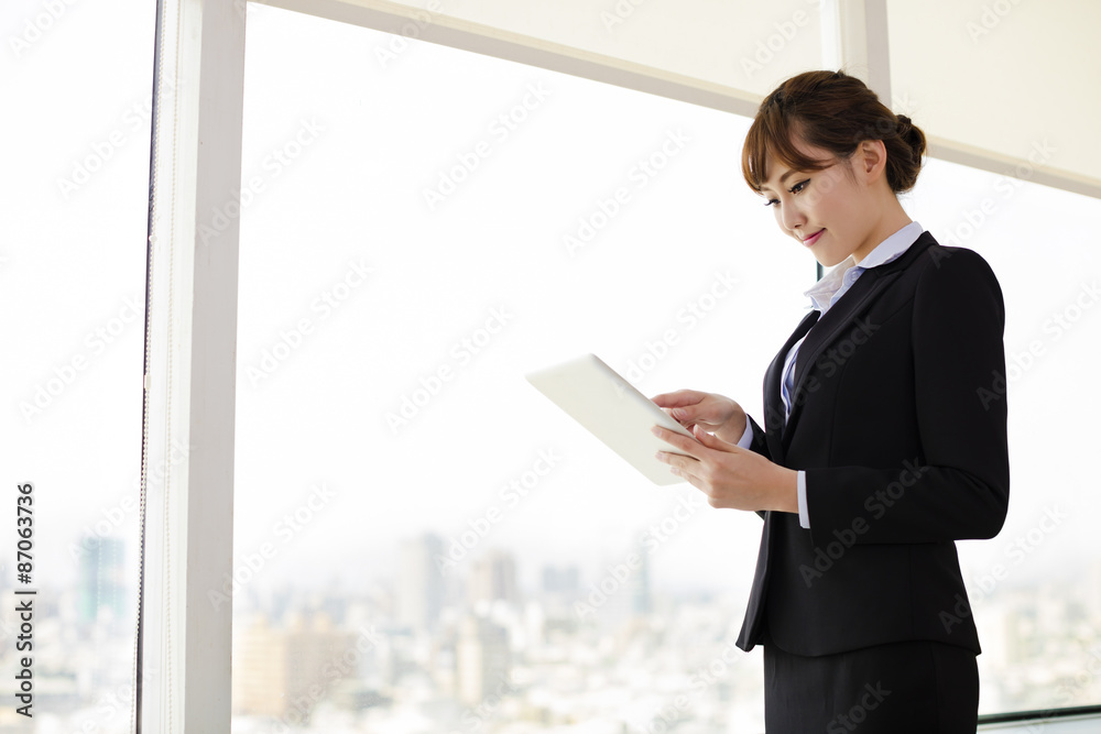 Businesswoman Working On Tablet Computer in Office Businesswoman Working On Tablet Computer in Office