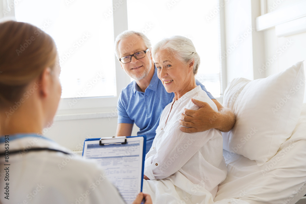 Fototapeta premium senior woman and doctor with clipboard at hospital