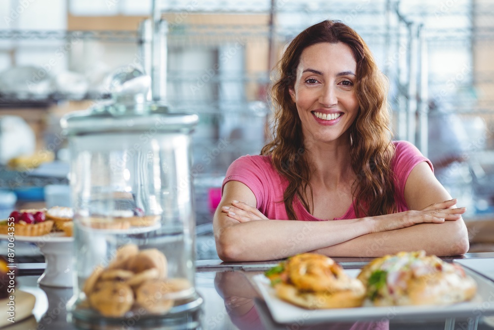 Pretty brunette smiling at camera behind counter Pretty brunette smiling at camera behind counter