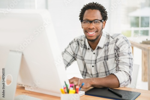 Portrait of smiling casual businessman working with computer