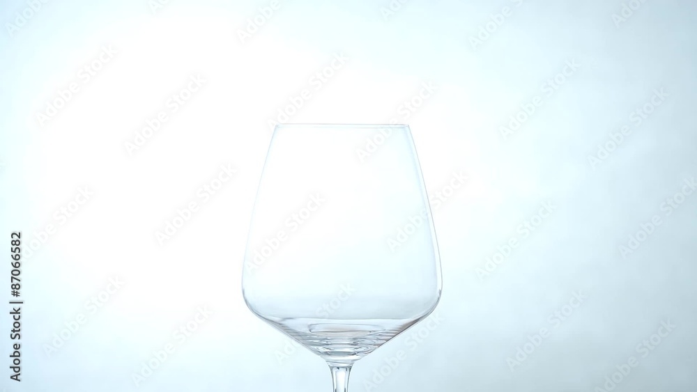 Red wine pouring into glass / white background Red wine pouring into glass / white background